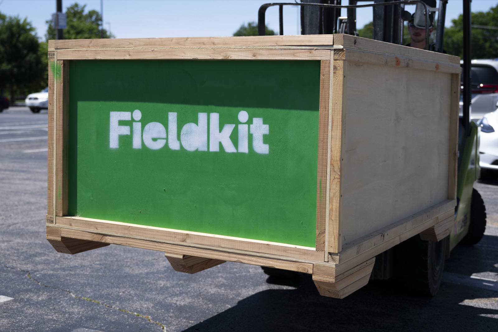 Fieldkit-stenciled wooden shipping crate carrying the Festival of Miles build, on a forklift