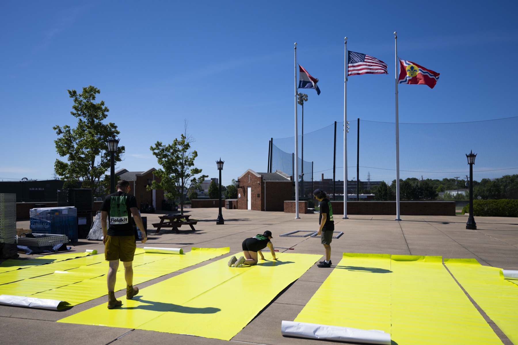 Fieldkit install crew laying campaign-yellow ground graphics on the concourse at Festival of Miles in St. Louis